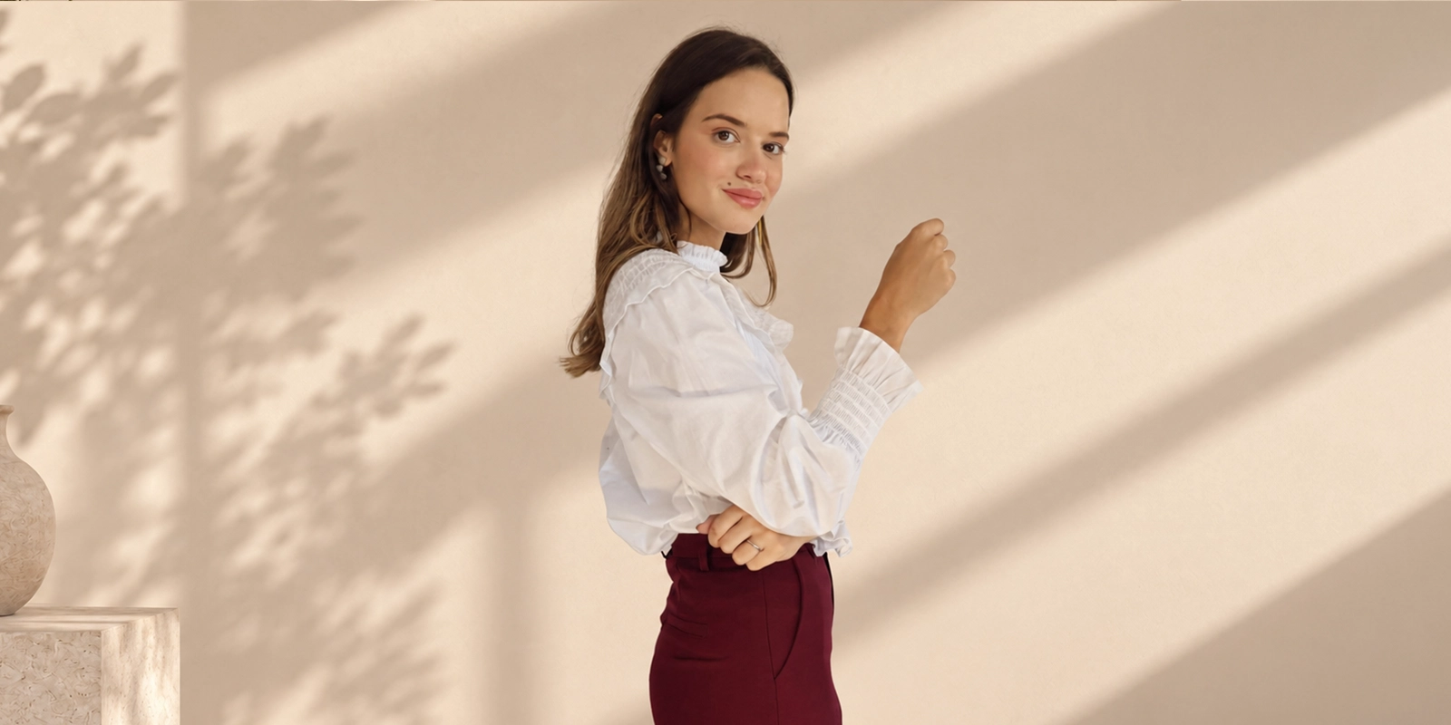 Modelo con blusa blanca de volantes y pantalón burdeos de Panttac