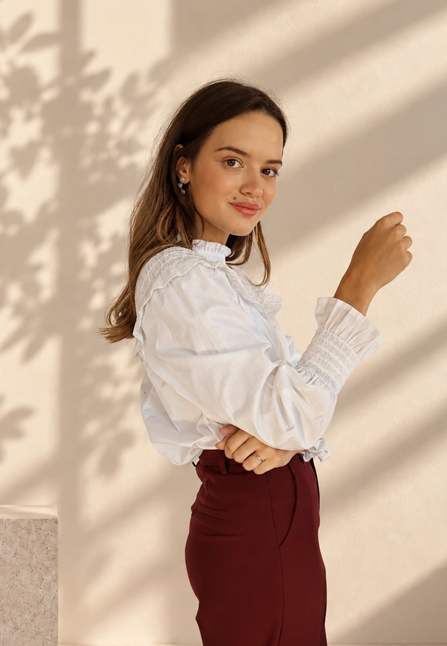 Modelo con blusa blanca de volantes y pantalón burdeos de Panttac