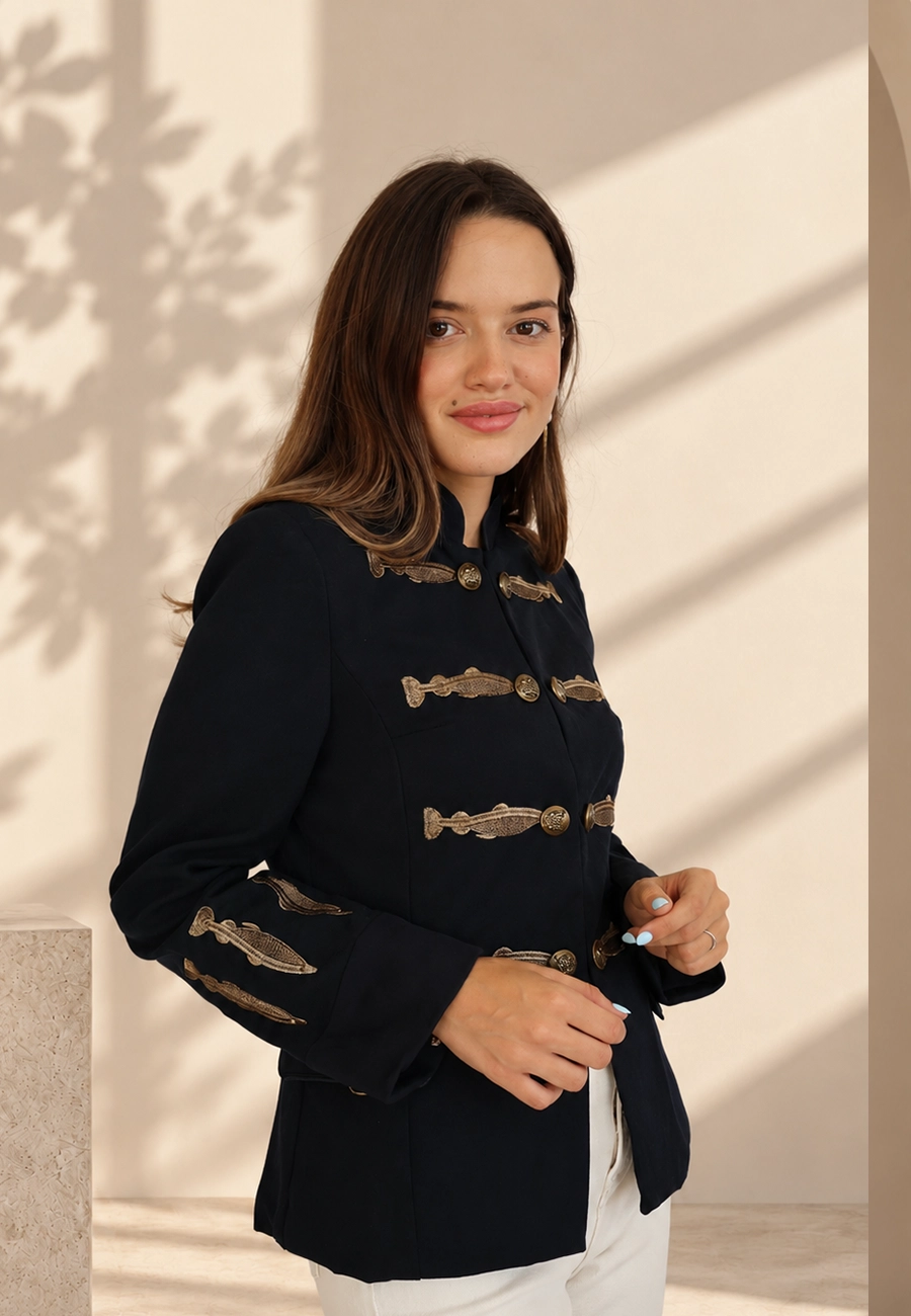 Modelo de moda femenina con chaqueta azul marino y bordados dorados de Panttac
