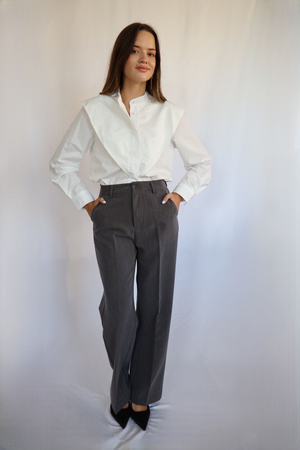 Pantalón gris marengo de mujer con bolsillos delanteros y tapillas finas decorativas en la parte trasera.