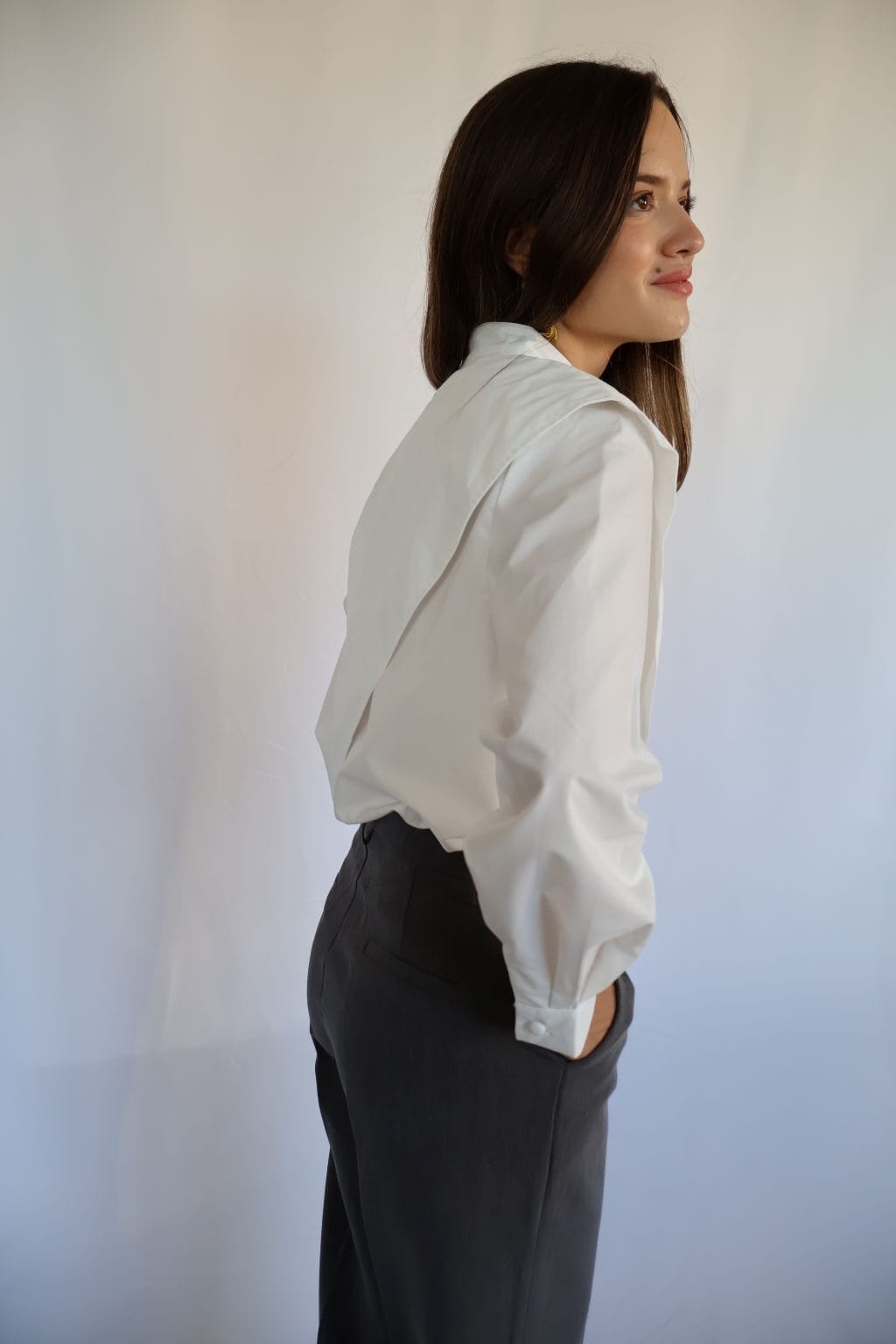 Pantalón gris marengo de mujer con bolsillos delanteros y tapillas finas decorativas en la parte trasera.