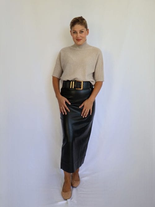 Jersey de punto beige de mujer con manga corta hasta el codo, de canalé, combinado con falda negra de polipiel.