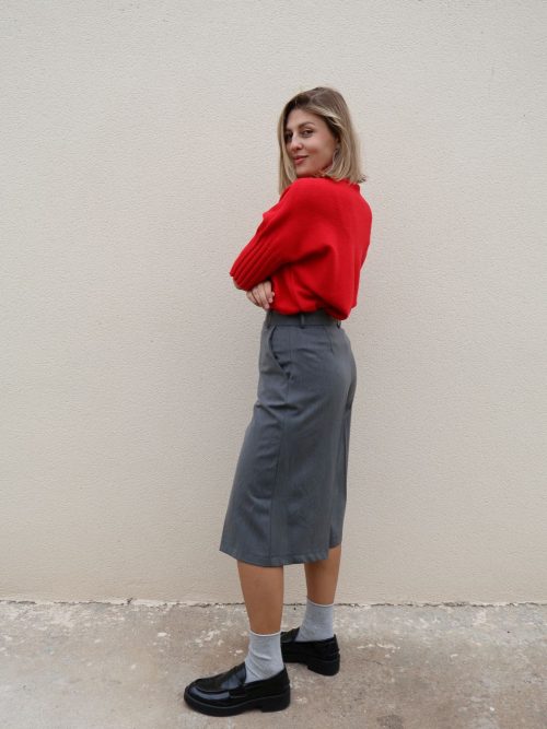 Bermuda gris de mujer PANTTAC de corte ancho, con bolsillos y largo por debajo de la rodilla, combinada con jersey rojo y mocasines negros.